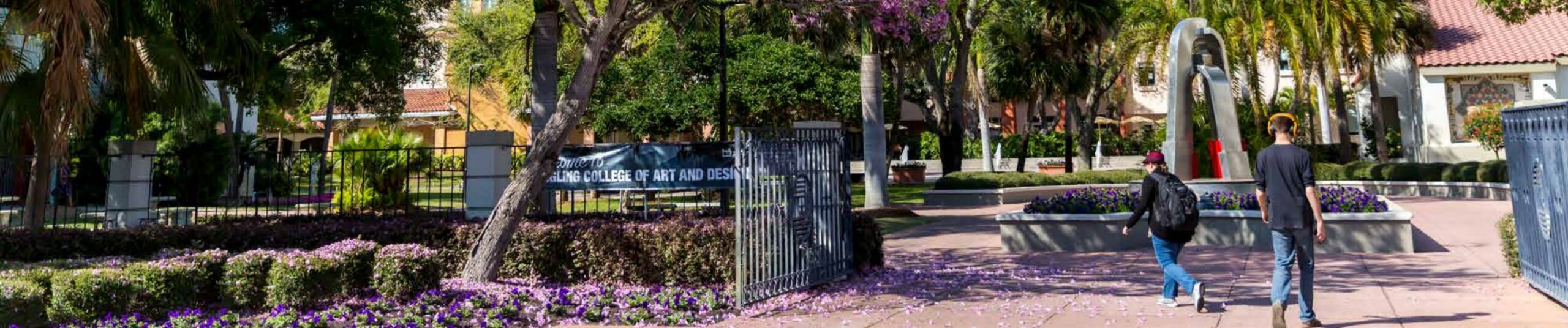 Two students walking through Ringling College's front gate.