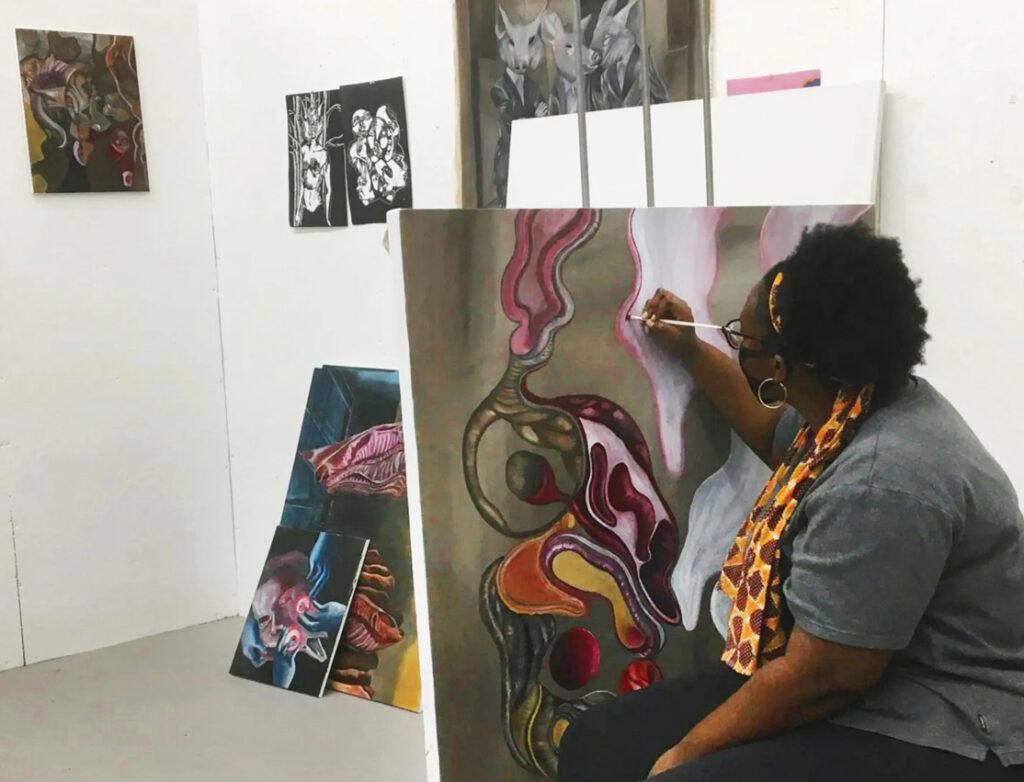 A woman painting at an art gallery