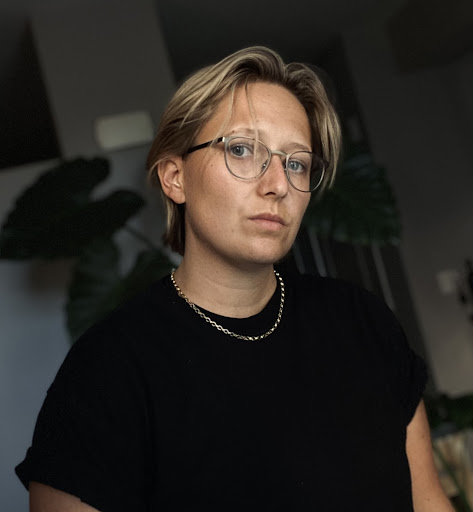 A photo of a blonde woman looking sternly into the camera