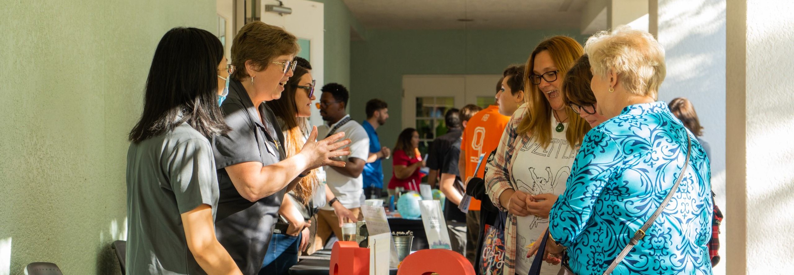 people standing around a table, attending open houose