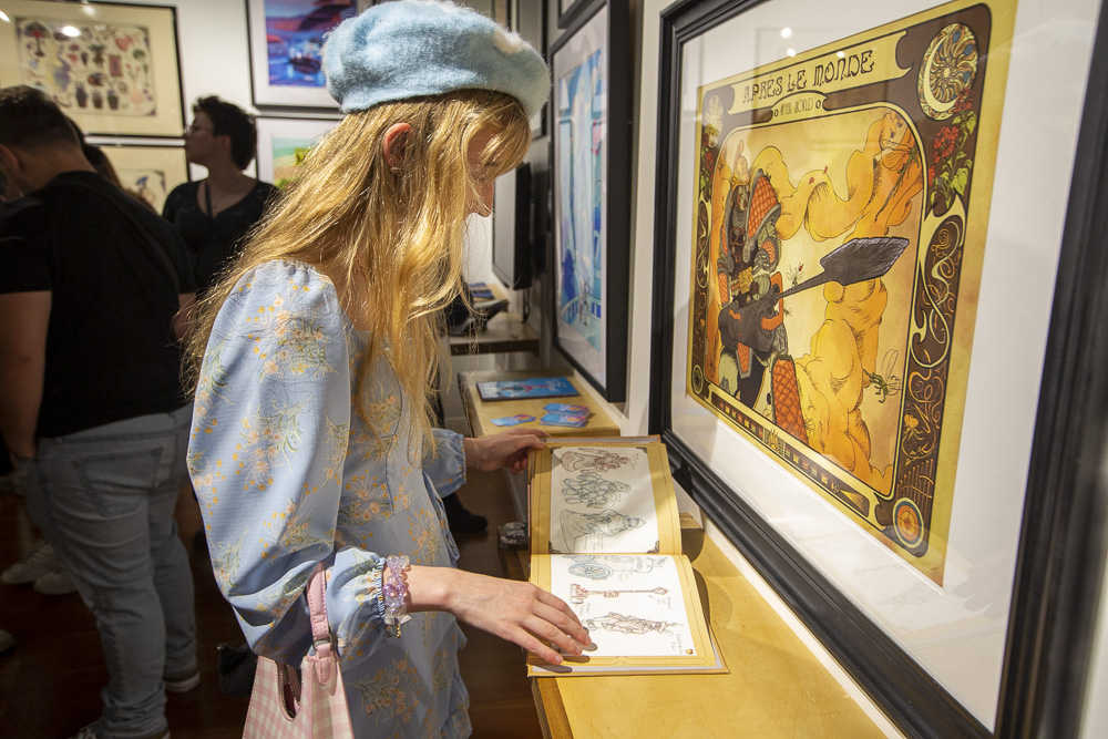 Person with long blonde hair reading a display book.