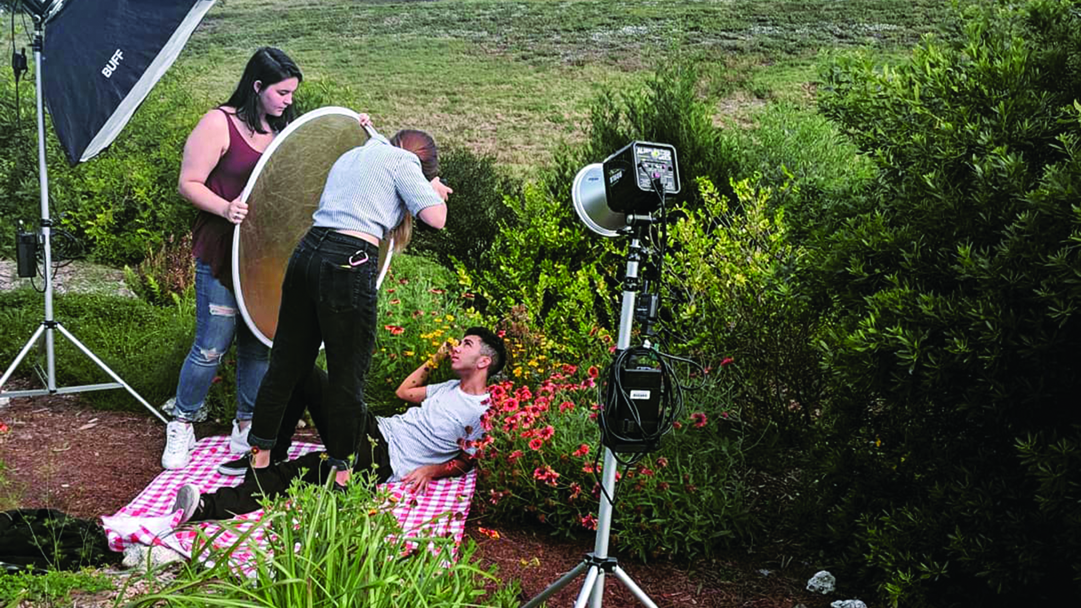 An outdoor photo shoot with three people occupying different jobs.