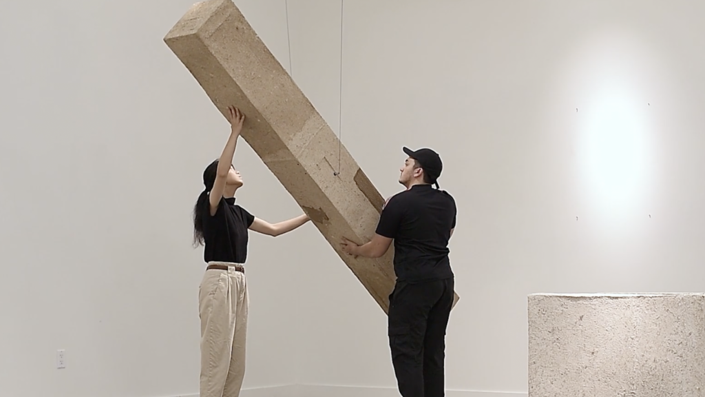 Two people activating a sculpture installation.