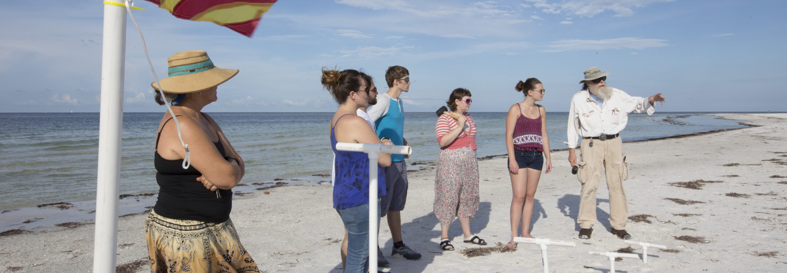 People standing and pointing on a beach