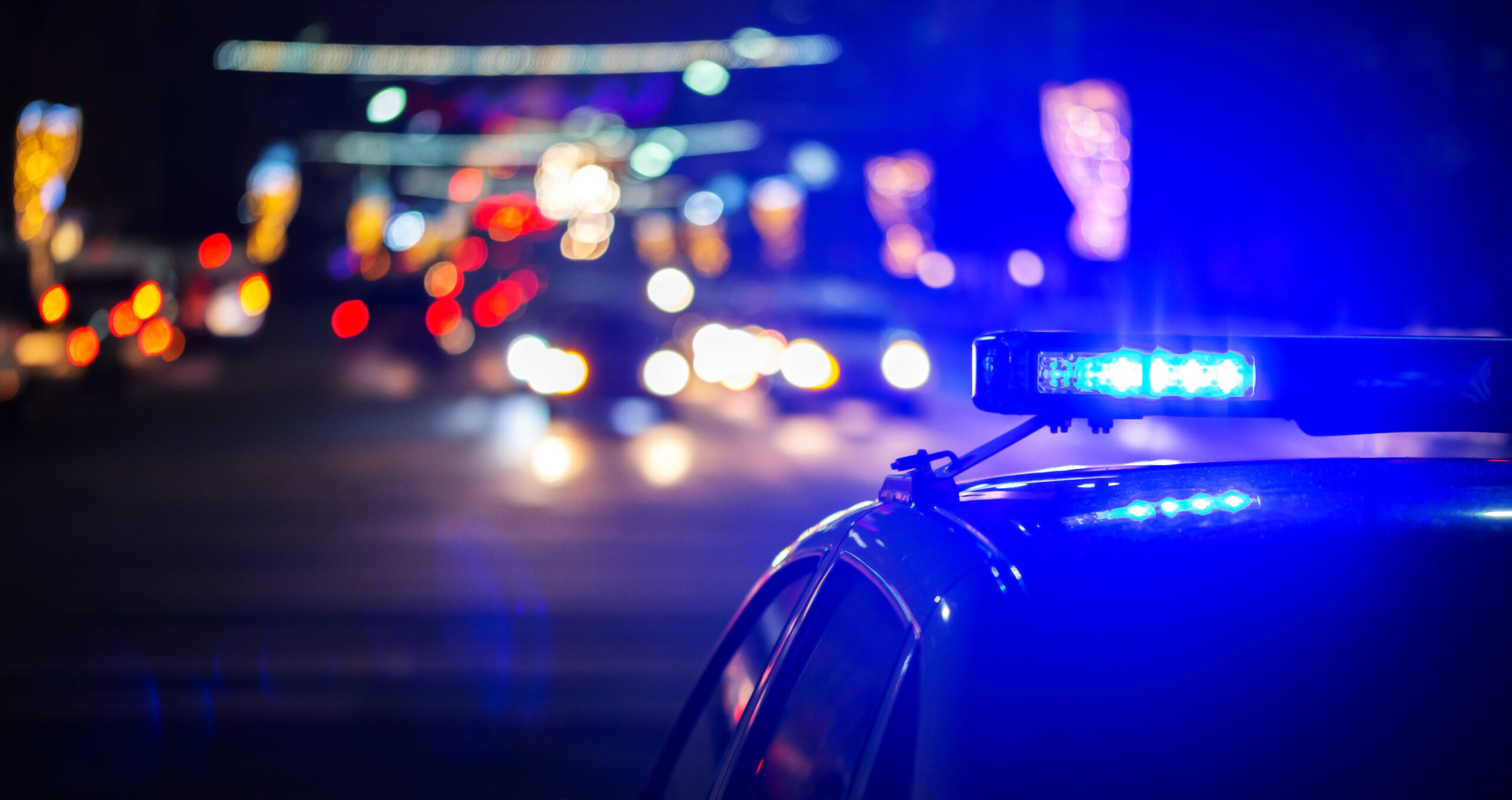 Police car with lights on in traffic.