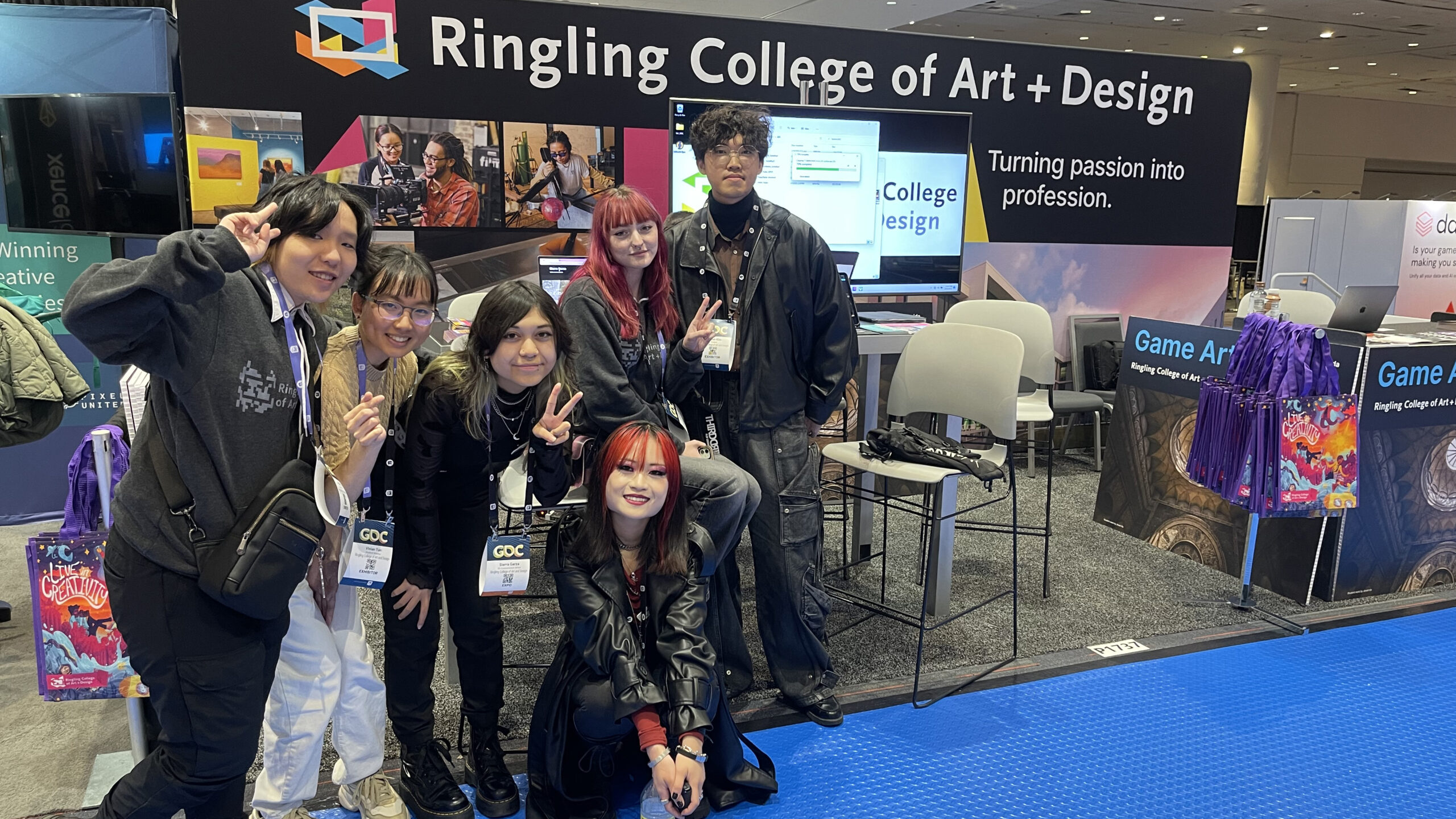 A group of students stand in front of a colorful Ringling College booth at the Game Developers Conference