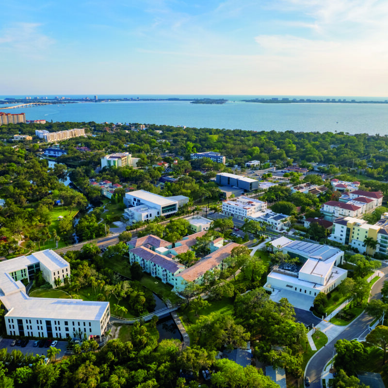 bird's eye view of campus with water in the distant.
