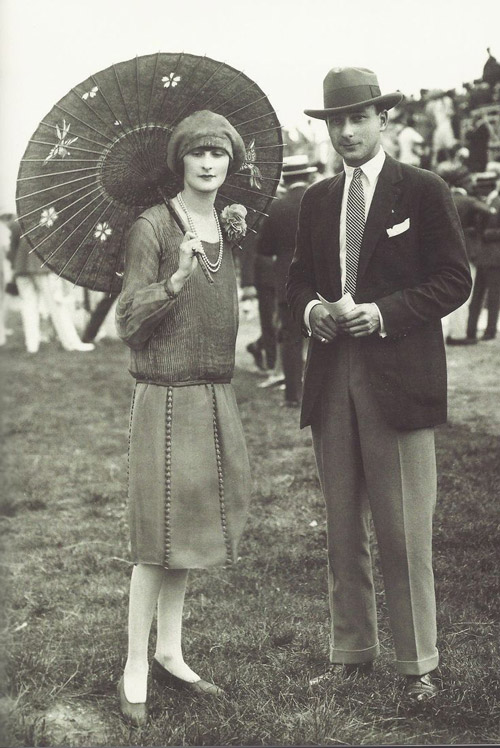 1920s couple in fashionable attire with parasol at an outdoor event