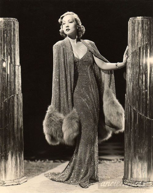 1930s woman wearing a glamorous evening gown with fur-trimmed wrap