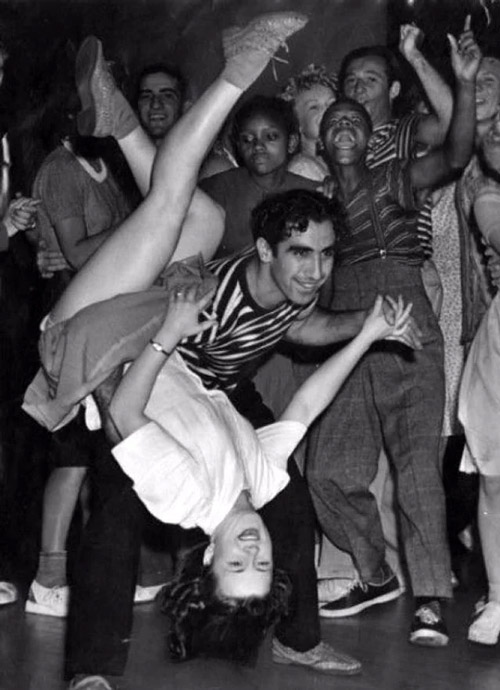 1940s dancers celebrating in a crowded social dance setting