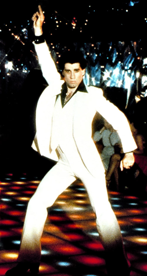1970s dancer performing in a white suit under disco lighting