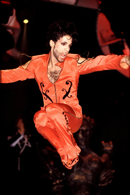 1980s performer wearing a bold stage costume mid-performance