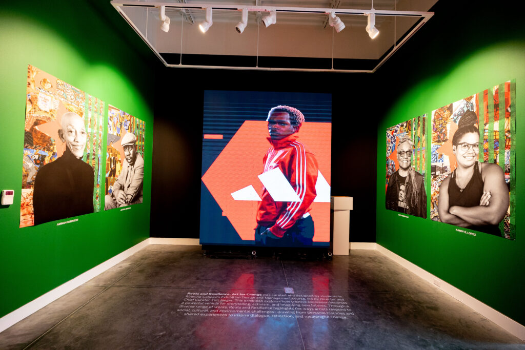 A green walled room with colorful posters of African-American artists and a large screen centered in a room. 