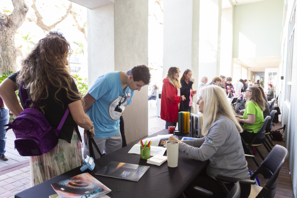 Open House fair visitors at tables.