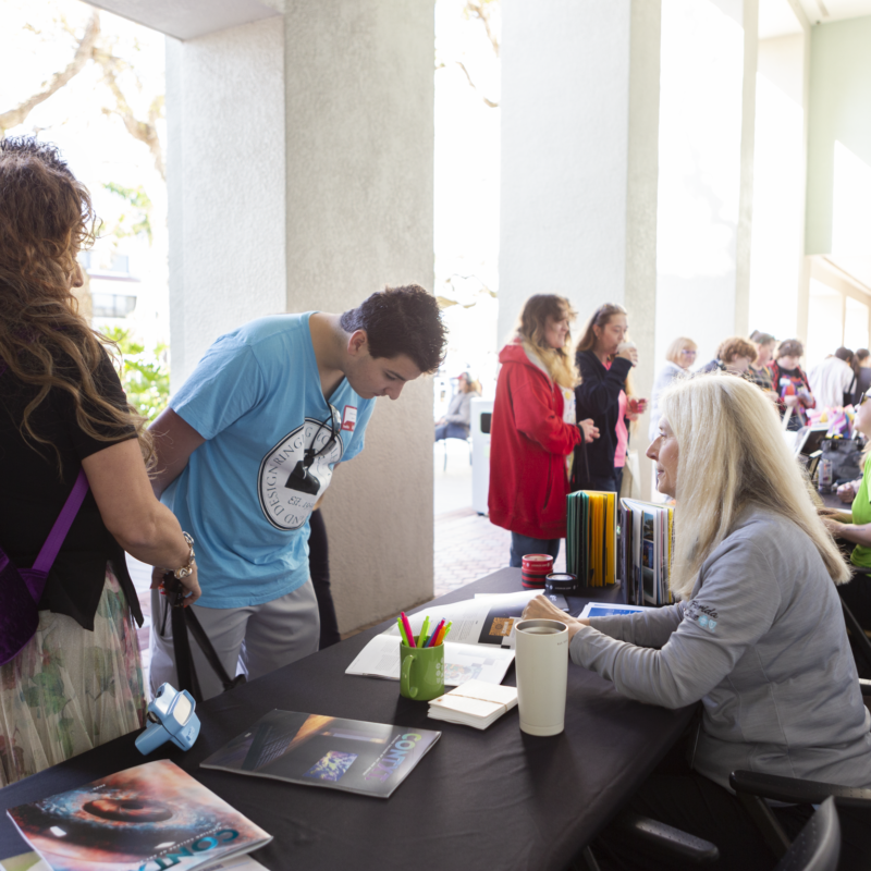 Open House fair visitors at tables.
