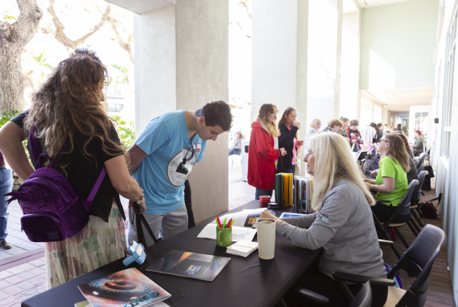 Open House fair visitors at tables.