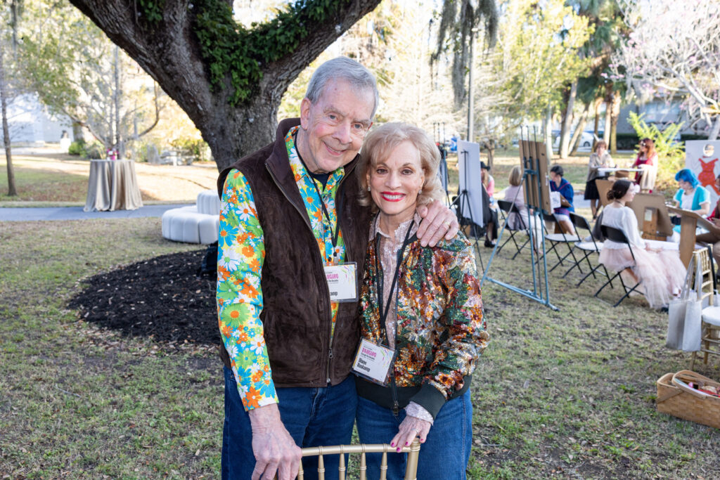 Alumni Couple at Outdoor Gathering Two alumni standing together and smiling at an outdoor campus event.