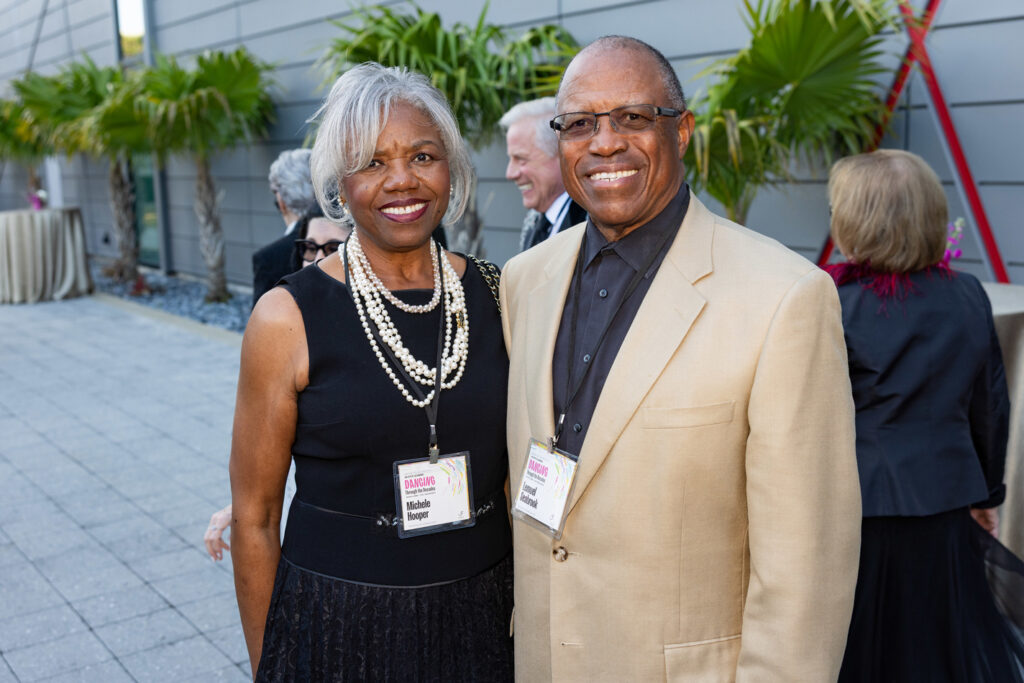 Alumni Couple at Evening Event Two alumni dressed formally, posing together at an outdoor evening event.