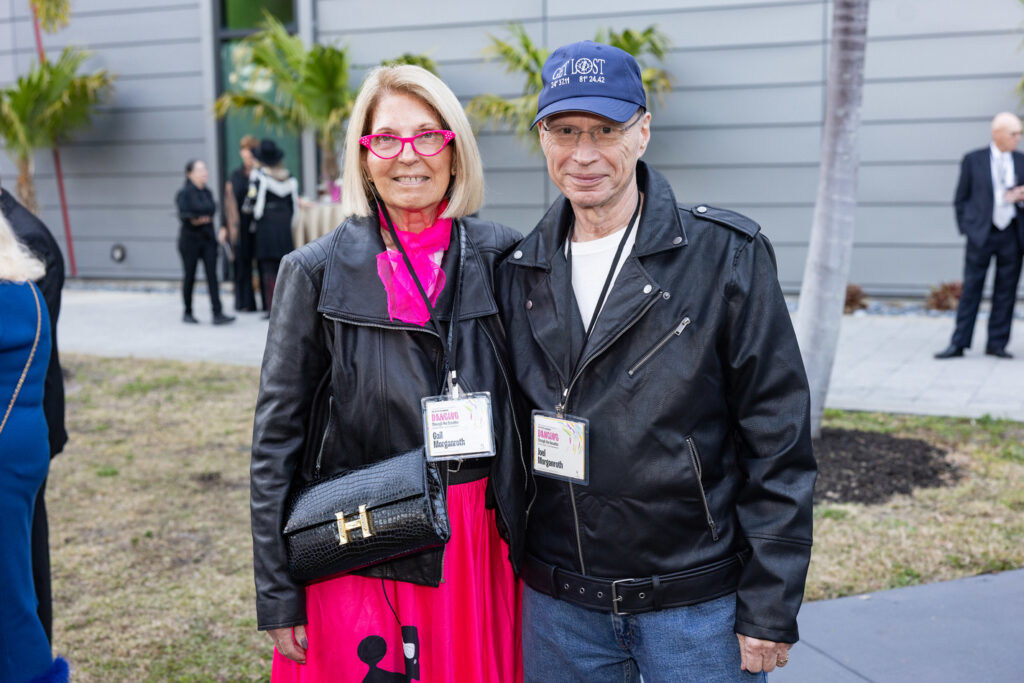 Alumni Couple at Campus Event Two alumni wearing name badges stand together outdoors during a campus gathering.