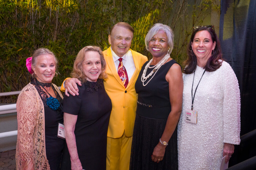 Alumni Group at Campus Event Small group of alumni posing together outdoors at a campus gathering.