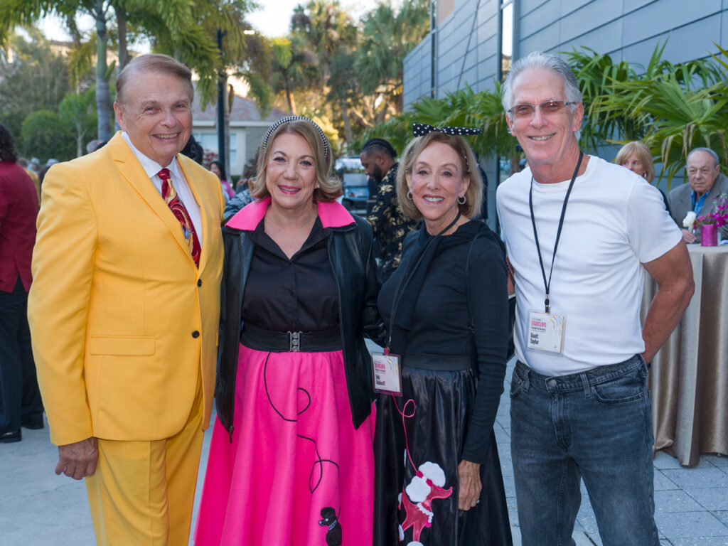 Alumni Friends at Reception Group of alumni smiling and posing together at an outdoor reception.