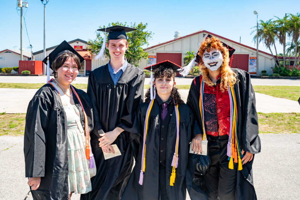 Graduates Outdoors Graduates posing together outdoors in commencement regalia.