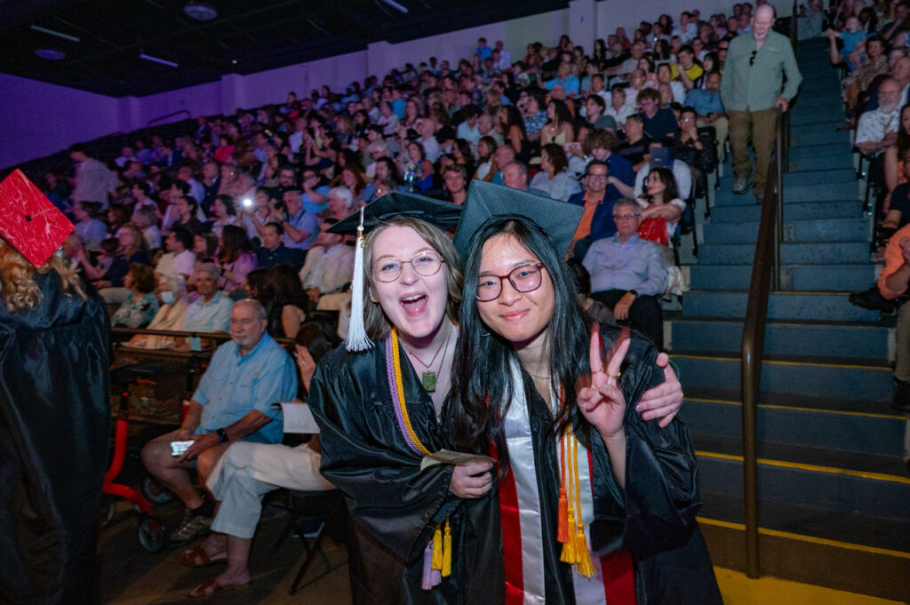 Students at 2026 Commencement Students smiling and posing in the audience during commencement.