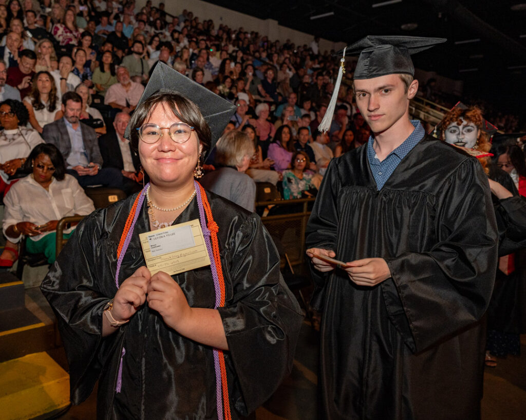 Graduate at 2026 Commencement Graduate holding commencement program inside the ceremony venue.