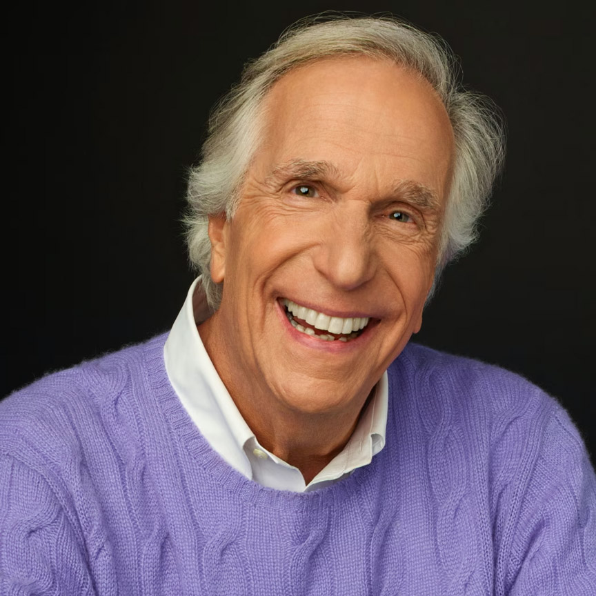 Image of a gentleman smiling wearing a purple sweater