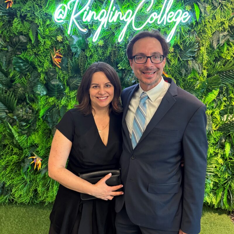 two people in front of green leafy wall
