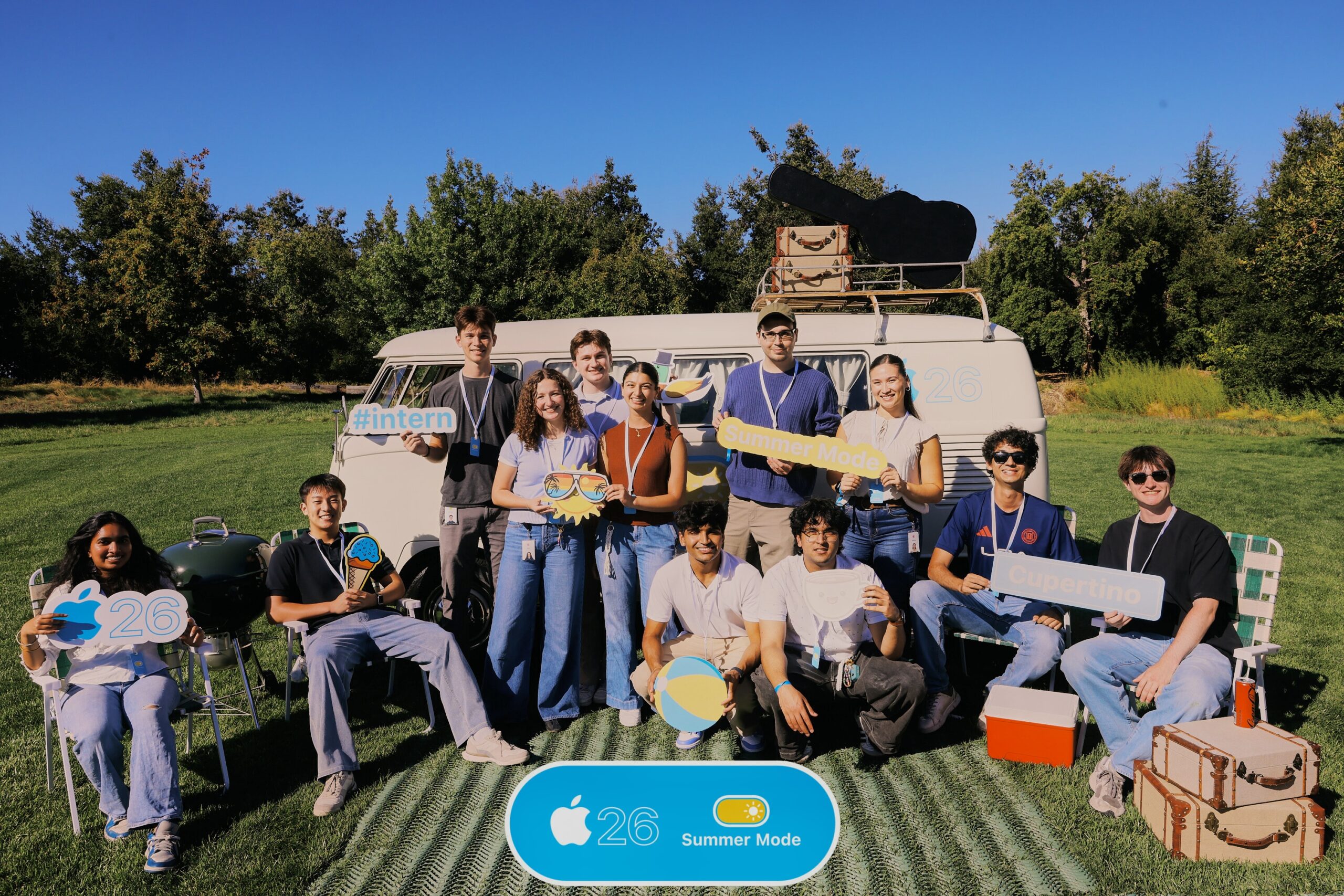 interns posing on a lawn in front of a van