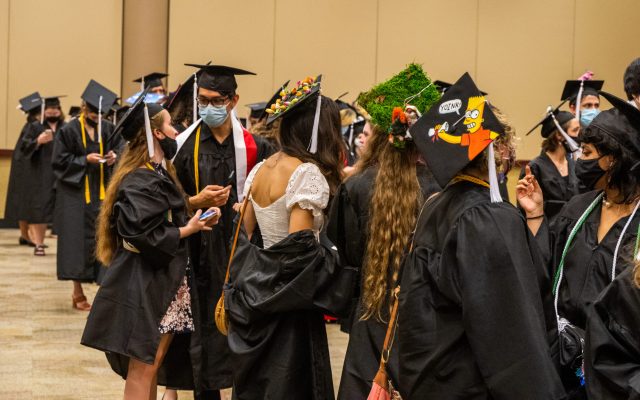 Students get ready for the ceremony and show off their decorated caps.